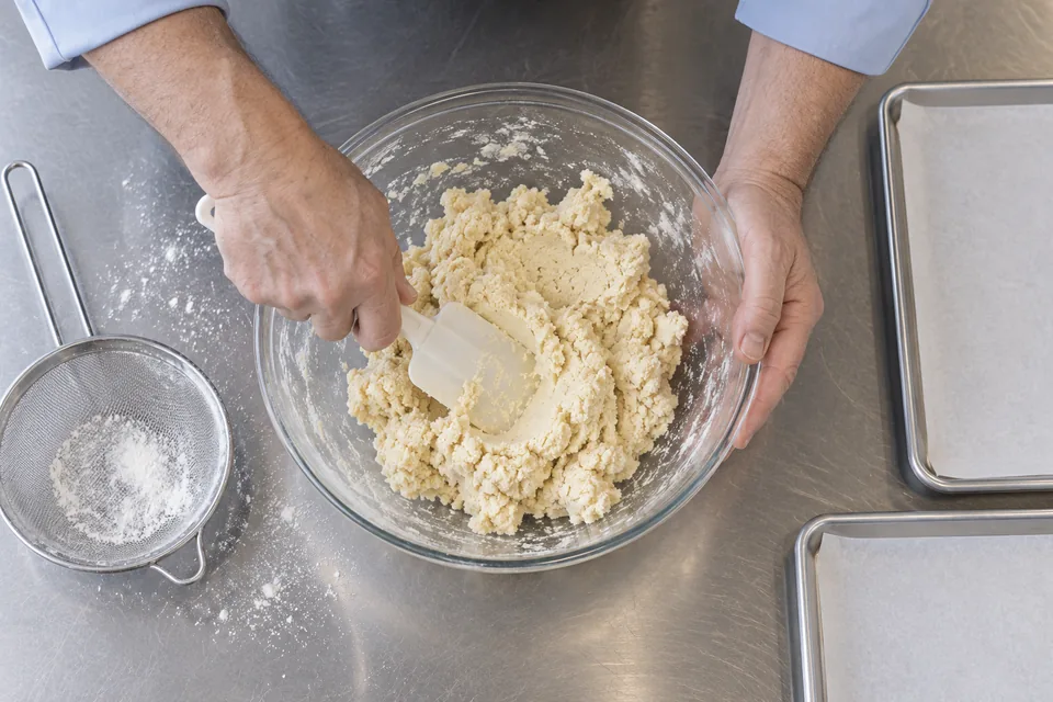 Overhead view of shortbread dough being pressed together in a bowl.